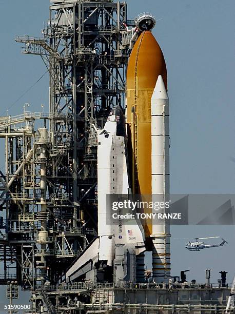 Helicopter flys by launch pad 39-B and the space shuttle Discovery at the Kennedy Space Center, FL 07 March 2001. Discovery and a crew of seven are...