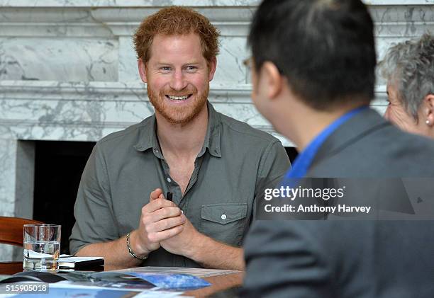 Prince Harry speaks with MapAction volunteer Wai-Ming Lee during a briefing by MapAction to learn more about the charity's response to the recent...