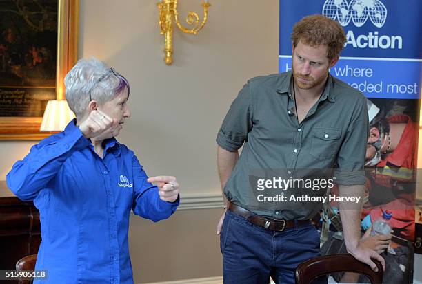 Prince Harry speaks with MapAction volunteer Kirsty Ferns during a briefing by MapAction to learn more about the charity's response to the recent...