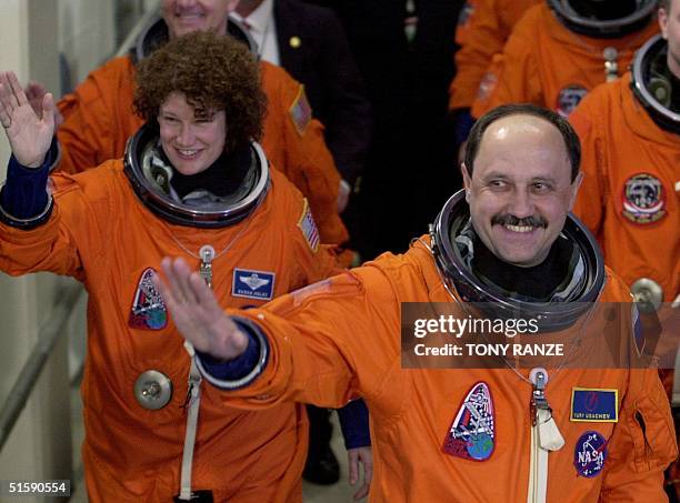 Space shuttle Discovery Mission Specialist Susan Helms follows Mission Specialist Yury Usachev as they depart the Operations and Checkout building...