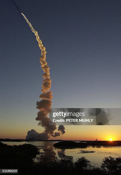 As the sun comes up the space shuttle Discovery climbs in to orbit after blasting off launch pad 39-B at the Kennedy Space Center, FL, 08 March 2001....