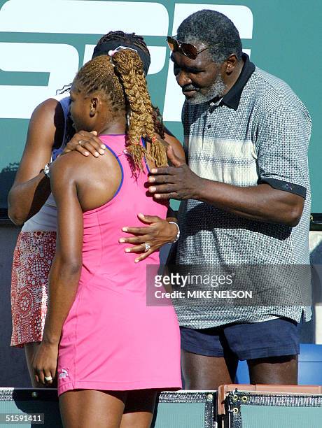 Serena Williams, winner of the Tennis Masters Series, is hugged by her sister, Venus and her father Richard after her victory against Kim Clijsters...