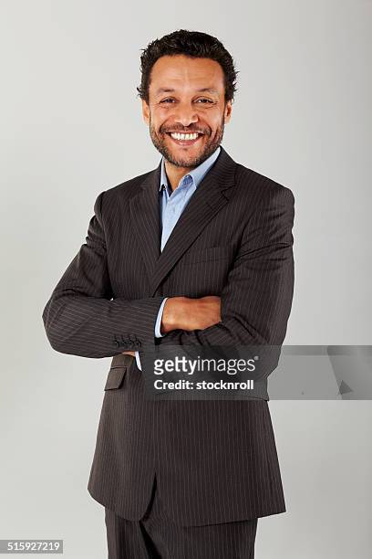 confident business executive with his arms crossed - hispanic businessman stock pictures, royalty-free photos & images
