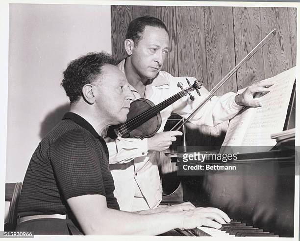 Violinist Jascha Heifetz and pianist Arthur Rubinstein practice for a concert in aid of British War Relief and the Royal Air Force Benevolent Fund.