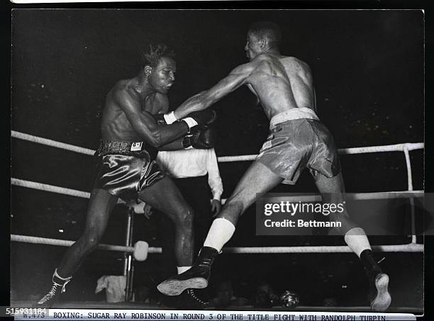 London, England: Boxing: Sugar Ray Robinson in round 3 of the title fight with Randolpf Turpin, British boxer at Earls Court.