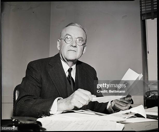 John Foster Dulles seated at desk. Undated photograph.