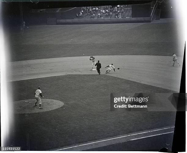 Umpire Delmore watches as Willie Mays of the New York Giant steals second base in the first inning of a game against the Chicago Cubs. Chicago...