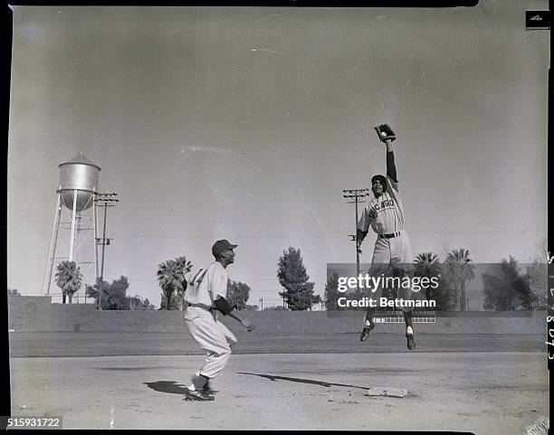 Mesa, AZ: Manager Phil Cavarretta of the Chicago Cubs believes he has something in this pair, shortstop Gene Baker and second baseman Ernie Banks,...