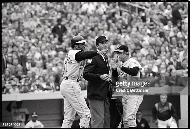 New York, NY: Frank Robinson and Oriole manager Earl Weaver holler and use hand signals to convince plate umpire Lou Dimuro that Robinson had been...