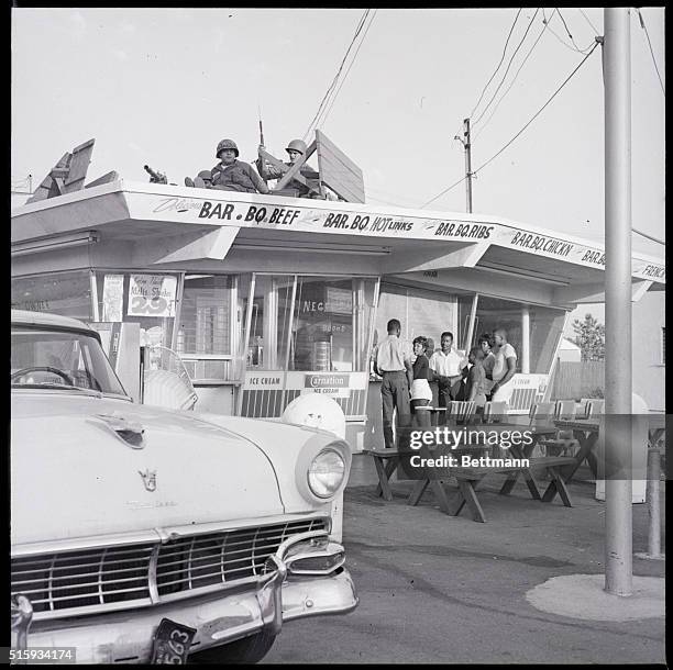 Los Angeles, CA: While customers wait for service below, National Guardsmen with a rifle and a .30 caliber machine gun keep their vigil up above at...