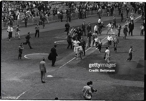 New York, NY: An enthusiastic crowd of fans greets Yankee slugger Mickey Mantle as he rounds third after smacking tie-breaking, winning home run in...