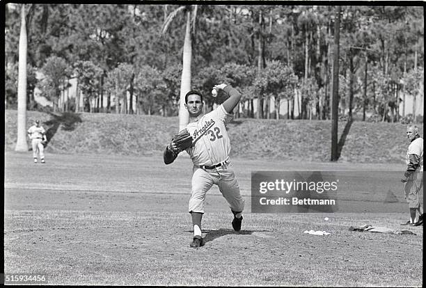 Vero Beach, FL: Sandy Koufax, Los Angeles Dodgers' star left hander, fires one during a spring training workout. A major chunk of Dodger Pennant...