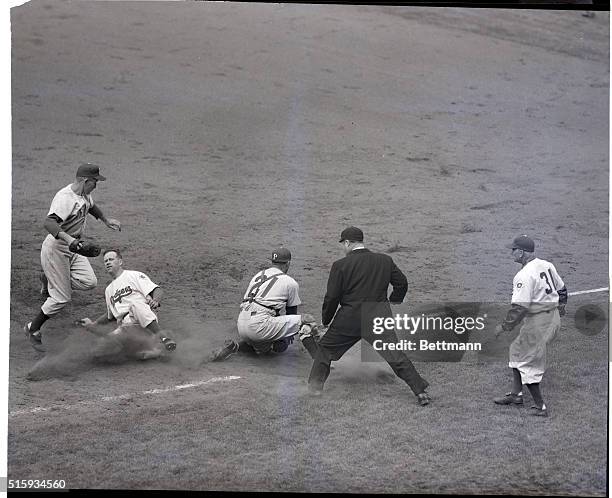 Brooklyn, NY: Capless Don Thompson of the Dodgers scurries back to first base after taking a wide turn when Philadelphia pitcher Robin Roberts threw...