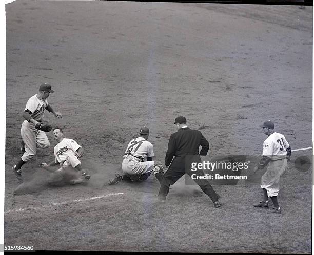 Brooklyn, NY: Capless Don Thompson of the Dodgers scurries back to first base after taking a wide turn when Philadelphia pitcher Robin Roberts threw...