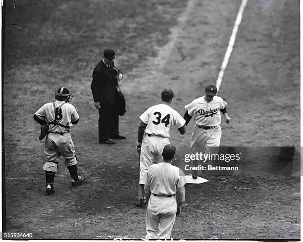 Brooklyn Dodgers' Eddie Miksis greets teammate Pee Wee Reese as he scores on his fourth inning homerun in the World Series against the Yankees.