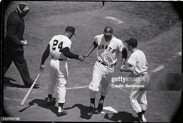 San Francisco, CA: San Francisco's high-flying rookie Willie McCovey is congratulated by Willie Mays and the Giants' batboy after hitting his first...