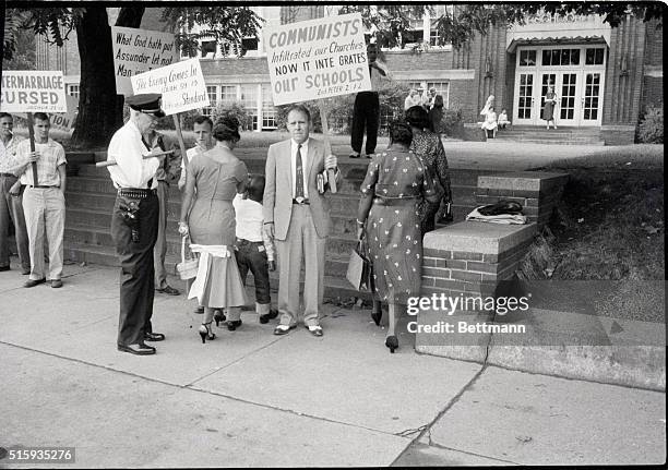 Nashville, TN- A Negro mother and her first grade child disregard segregationist as they enter a public school on the first day of classes. Negro...