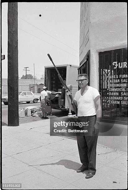 Los Angeles, CA- Aaron Mabroski, owner of Lad Furniture, guards his store with a shotgun as workers move furniture out. Looting, burning, and rioting...