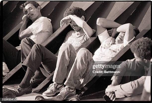 Miami Beach, FL-Some of the 37 Dominican refugees taken from a sailboat off the Florida Keys show their exhastion as they wait on the deck of the...