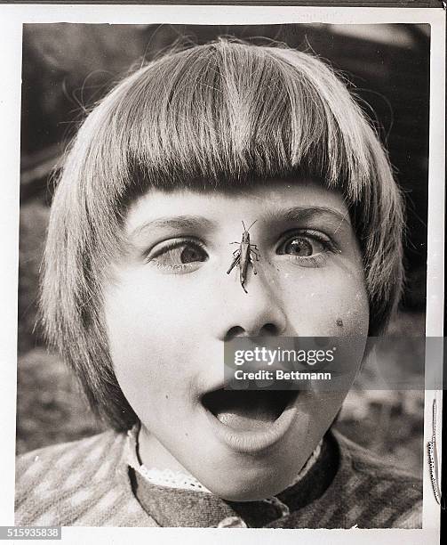 Peta Louise Skingley watches a grasshopper sitting on her nose. | Location: Woodford Green, England, UK.