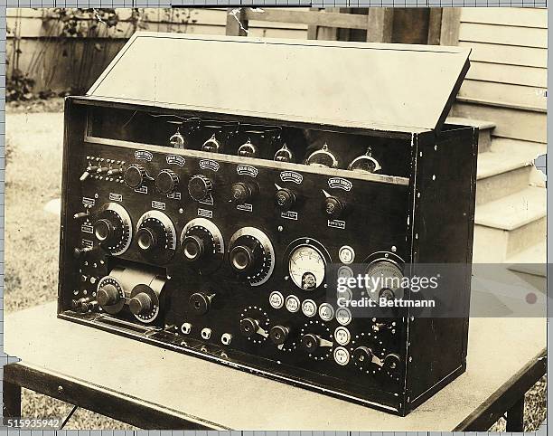 Picture shows a portrait of a radio transmitter sitting on a table outside.