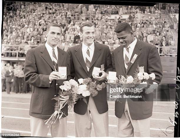 Helsinki, Finland- The three American winners of the Decathlon event at the Olympic Stadium here show their medals. In the center is Robert Mathias,...