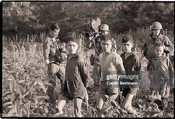 Da Nang, South Vietnam- Children and women , suspected of being Viet Cong, file past U.S. Marines. The women were among more than 100 suspects found...