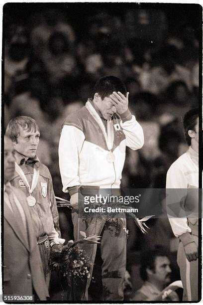 Los Angeles, CA- Japan's Hideaki Tomiyama is overcome as he stands on the podium after winning the gold medal in the 57kg wrestling competition...