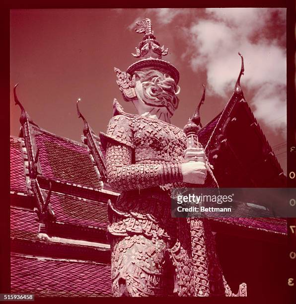 Shots of the colorful and grotesque statues that stand guard over one of the doors of the Emerald Temple in Bangkok, Siam, which was built 170 years...