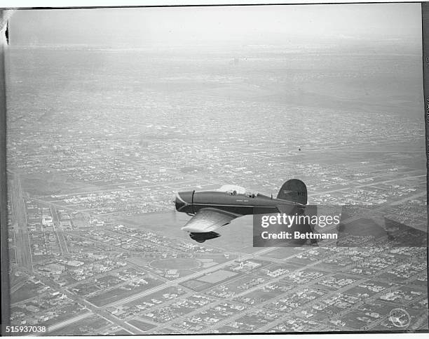 Colonel Charles A. Lindbergh and Mrs. Lindbergh flying high over Los Angeles at the dual controls of their new Lockheed "Sirius" plane. The plane was...