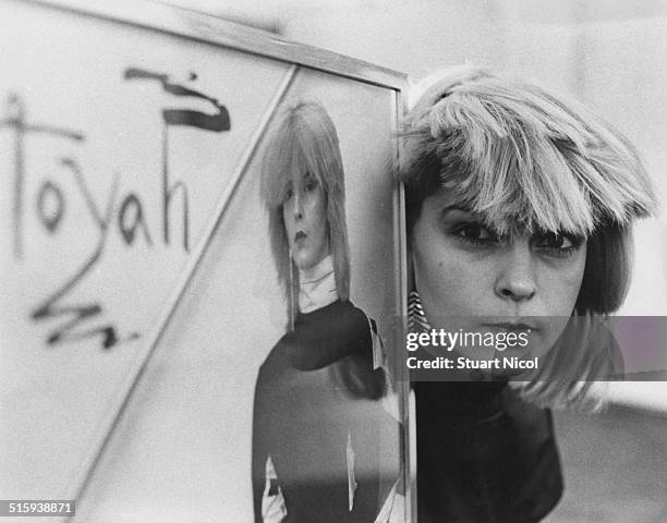 English singer and actress Toyah Willcox posing with some of her publicity material, 11th July 1980.