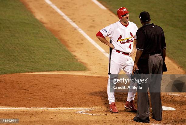 John Mabry of the St. Louis Cardinals argues with home plate umpire Chuck Meriwether after being called out on strikes during game four of the World...