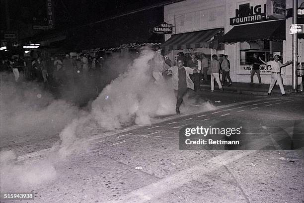 Univerity of California student runs from a grenade of exploding tear gas thrown by police in downtown Berkeley, California, during a 4,000 student...