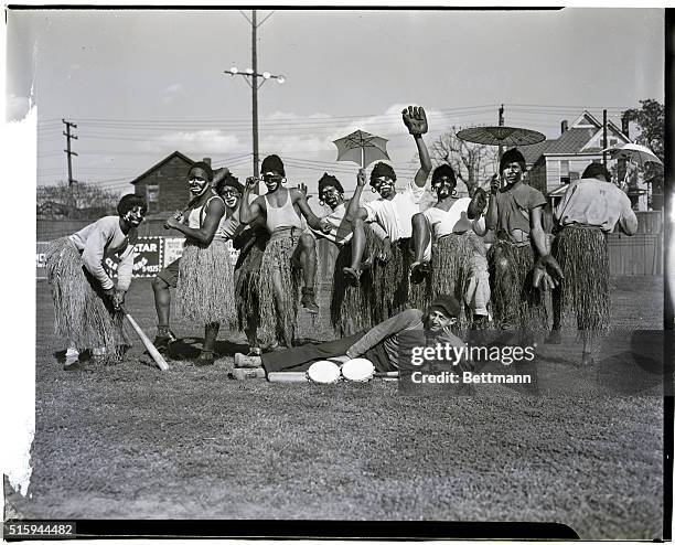 Players on the African Clowns, a black minor league baseball team, clown around in face makeup and grass skirts as part of a barnstorming tour where...