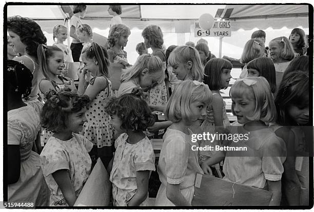 Young twin girls compete for the "most identical twin" award at the 10th annual Twins Day Festival in Twinsburg, Ohio. The festival is expected to...