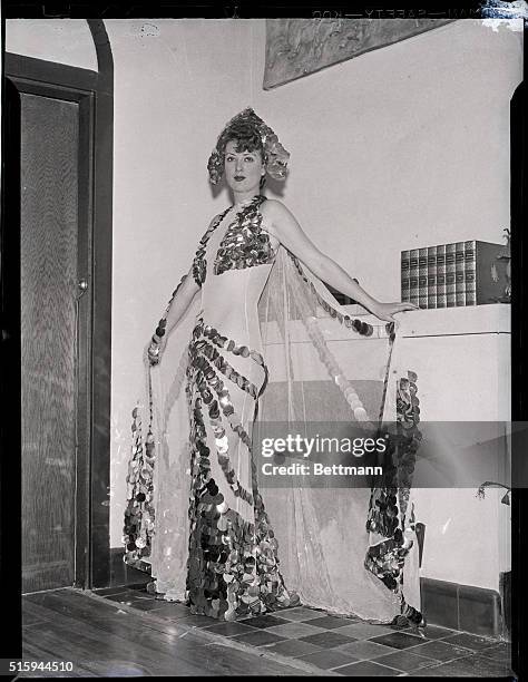 Gypsy Rose Lee wears an extravagant sequined gown on December 2, 1937. Lee, a burlesque dancer, models the costume she will wear for the Beaux Art...