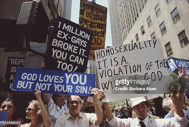 Homophobic demonstration during Gay Pride Day in New York City, 29th June 1986. The protestors hold placards reading 'God loves you but not your...