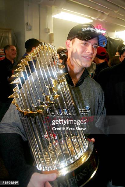 General manager Theo Epstein of the Boston Red Sox celebrates in the locker room with the Championship trophy after defeating the St. Louis Cardinals...