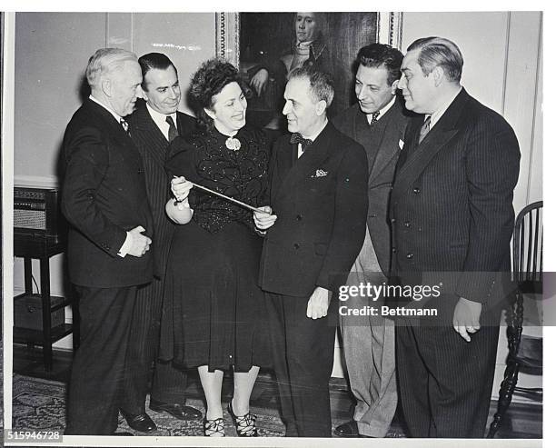 Opera singers and the general manager of the Metropolitan Opera present a silver and rosewood baton to conductor Bruno Walter before his debut with...