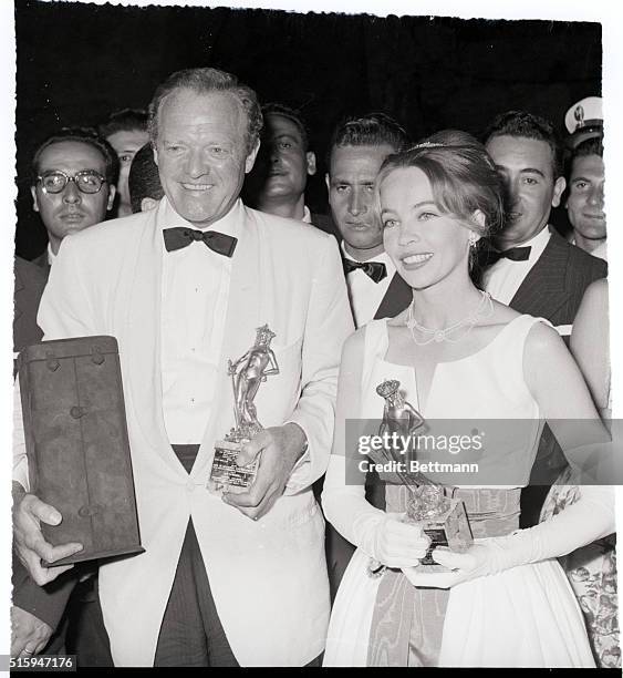 Taormina, Sicily: Film stars Van Heflin and Leslie Caron hold their "David" statuettes-the Italian equivalent of Hollyood's "Oscar"--during awards...