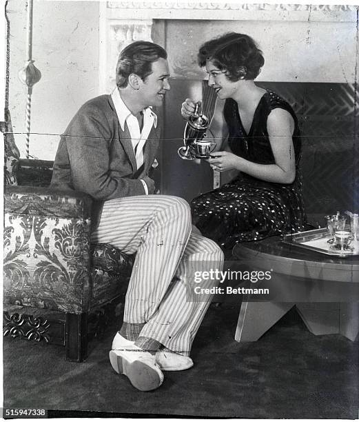 Joan Crawford pouring Douglas Fairbanks a cup of tea.