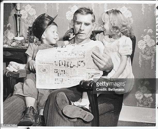 Castel Shannon, PA: A miner for 37 years, John Stutt, of Castel Shannon, uses his "Idel time" to read the "funnies" to his granchildren, "Butchie"...
