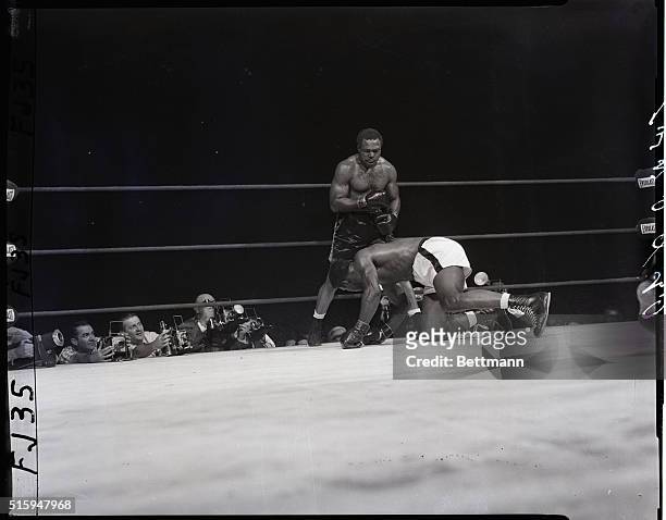 Chicago, IL: Archie Moore stands over Floyd Patterson afetr the latter slipped and fell to the canvasin the fourth round of their heavyweight title...