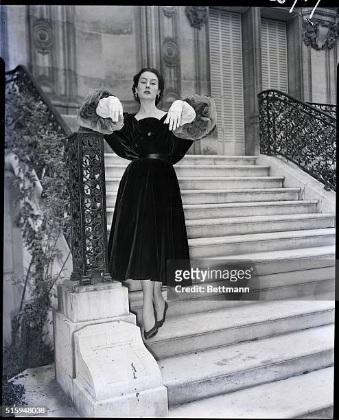 Paris, France: An imaginative black velvet evening dress with short skirt and long sleeves terminating in large roses made of Mousseline. From the...