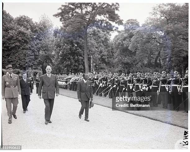 Paris, France: President Charles De Gaulle, with his customary stern face, passes in front of an honor guard at the Elysee Palace grounds, after the...