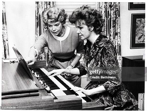 Geraldine Page learns how to play the harmonium for a part in the "The Umbrella". She is being taught by Ethel Smith.