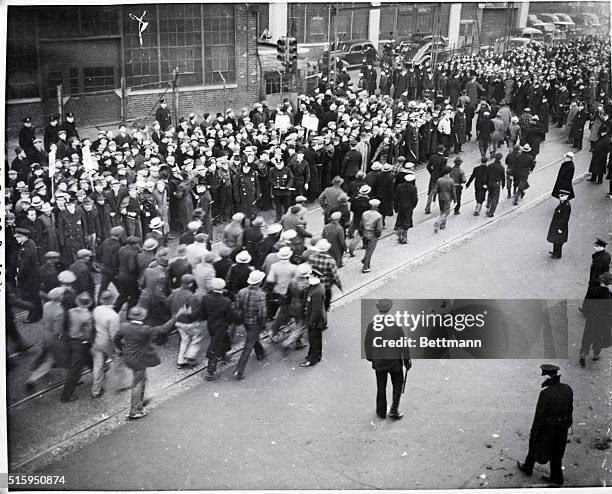 Detroit, MI: Thousands of striking United Automobile Workers Union pickets line the way to jeer as 200 Negro foundry workers enter the struck...
