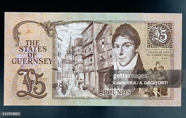 Pounds banknote reverse, view of Fountain Street in St Peter Port, portrait of Thomas de la Rue and envelope making machine. Guernsey, 20th century.