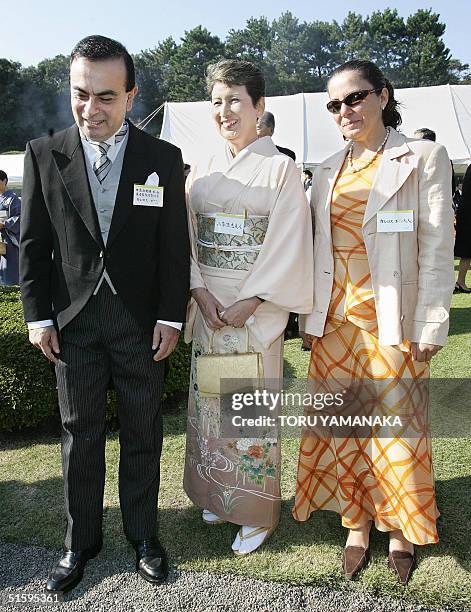 President of Japan's auto giant Nissan Motor, Carlos Ghosn and his wife Rita share a light moment with an unidentified Japanese woman clad in kimono...