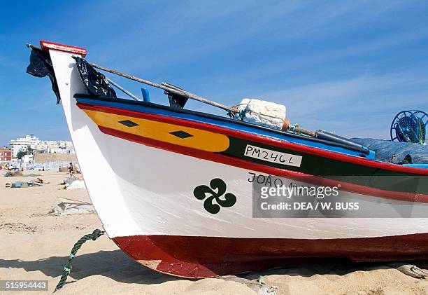 Painted bow of a fishing boat docked on the beach, Armacao de Pera, Algarve, Portugal.